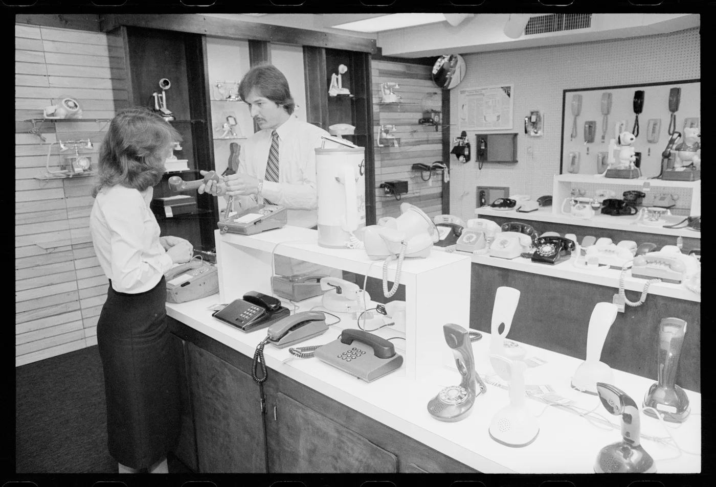 A salesperson demonstrates a telephone handset to a woman in a Washington shop in 1981