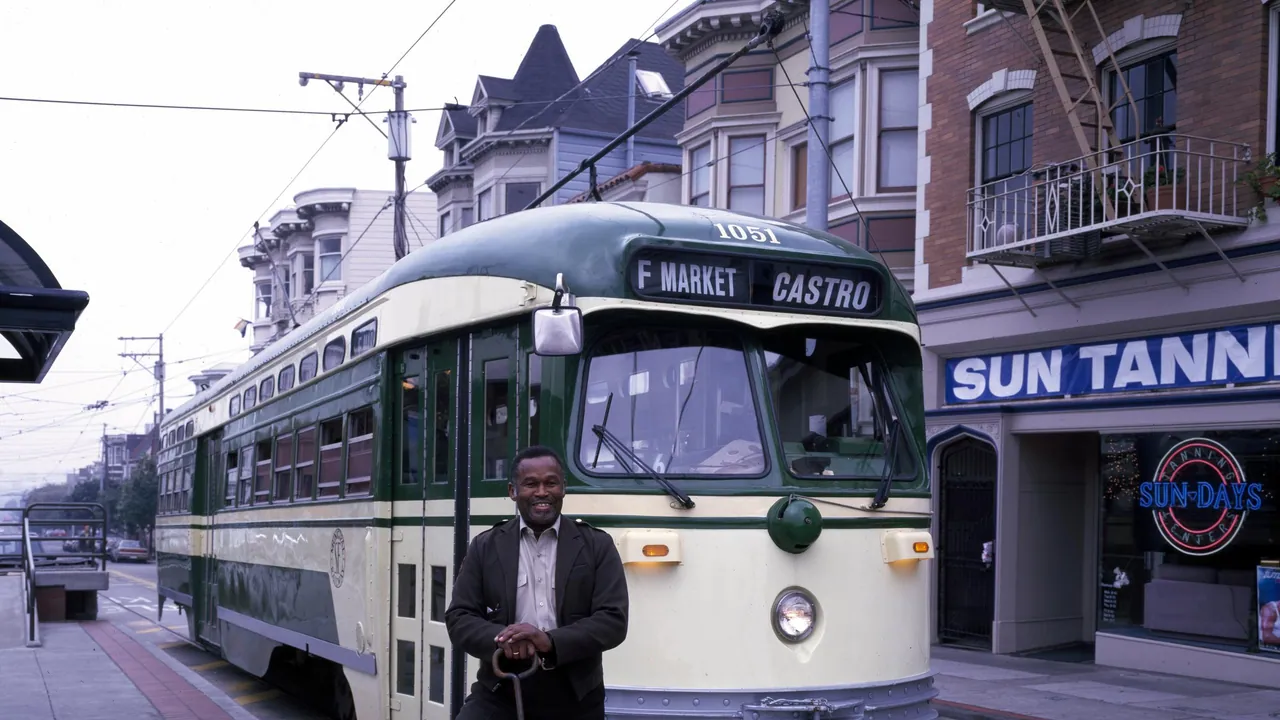 A uniformed professional driver stands beside a green and cream historic streetcar at the end of its city route