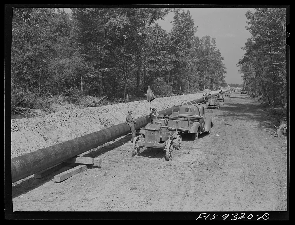 A gasoline-powered generator supplies pipeline welders working beside a rural Arkansas road in 1942