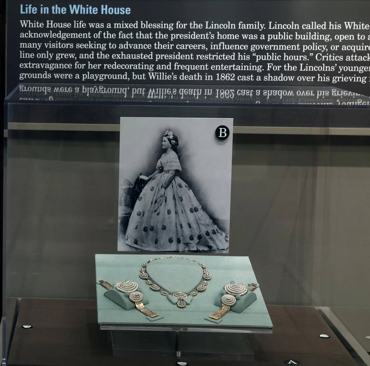 Mary Todd Lincoln's pearl necklace and bracelets sit in a museum display beneath her portrait