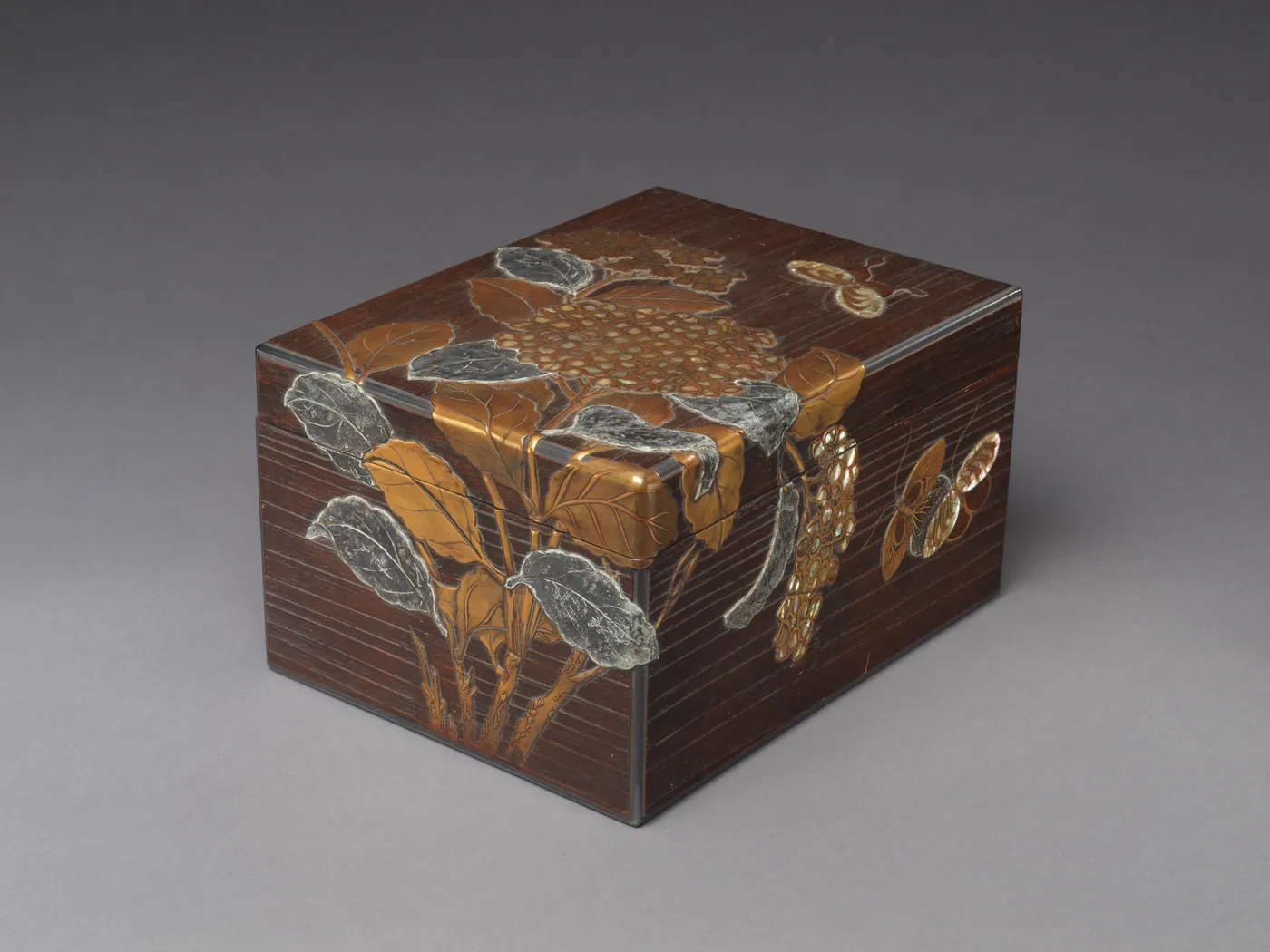 A dark brown Japanese lacquer document box decorated with gold and silver hydrangea leaves, flower clusters, and butterflies in raised relief.