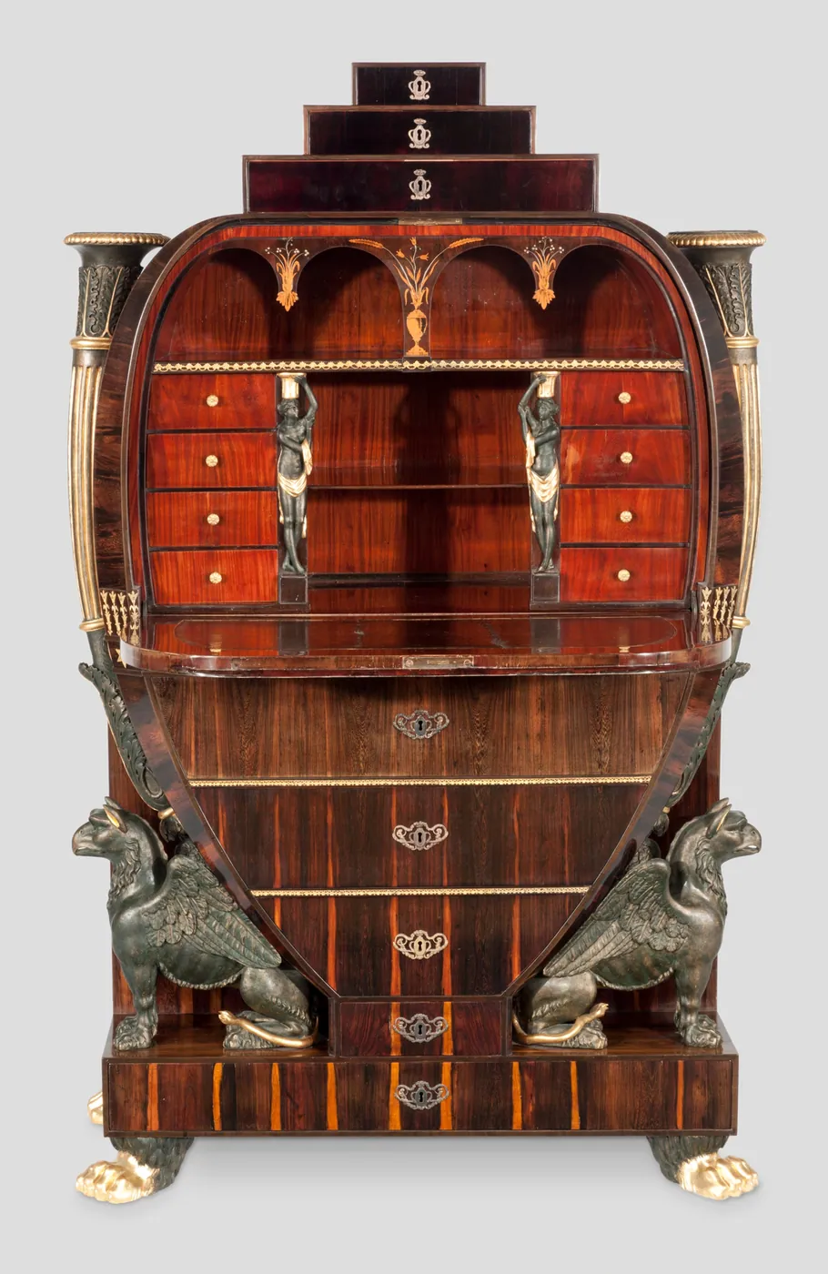 Viennese rosewood fall-front desk opened to show rows of small drawers and pigeonholes, flanked by bronze griffins and gilt columns