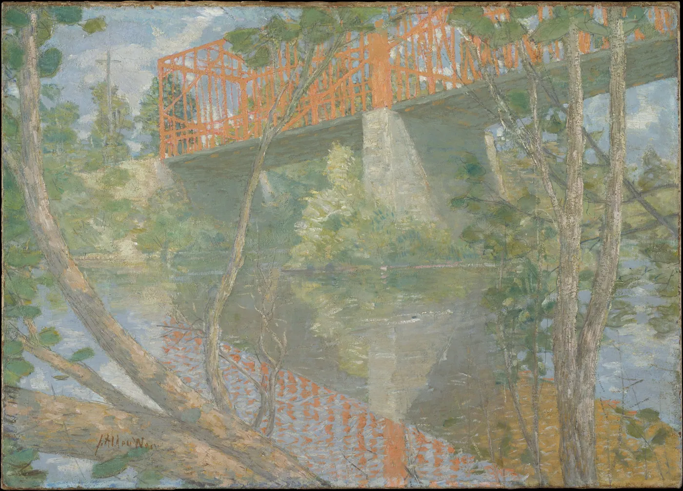 A red iron truss bridge on stone piers crossing a quiet river, seen through the twisting branches of trees.