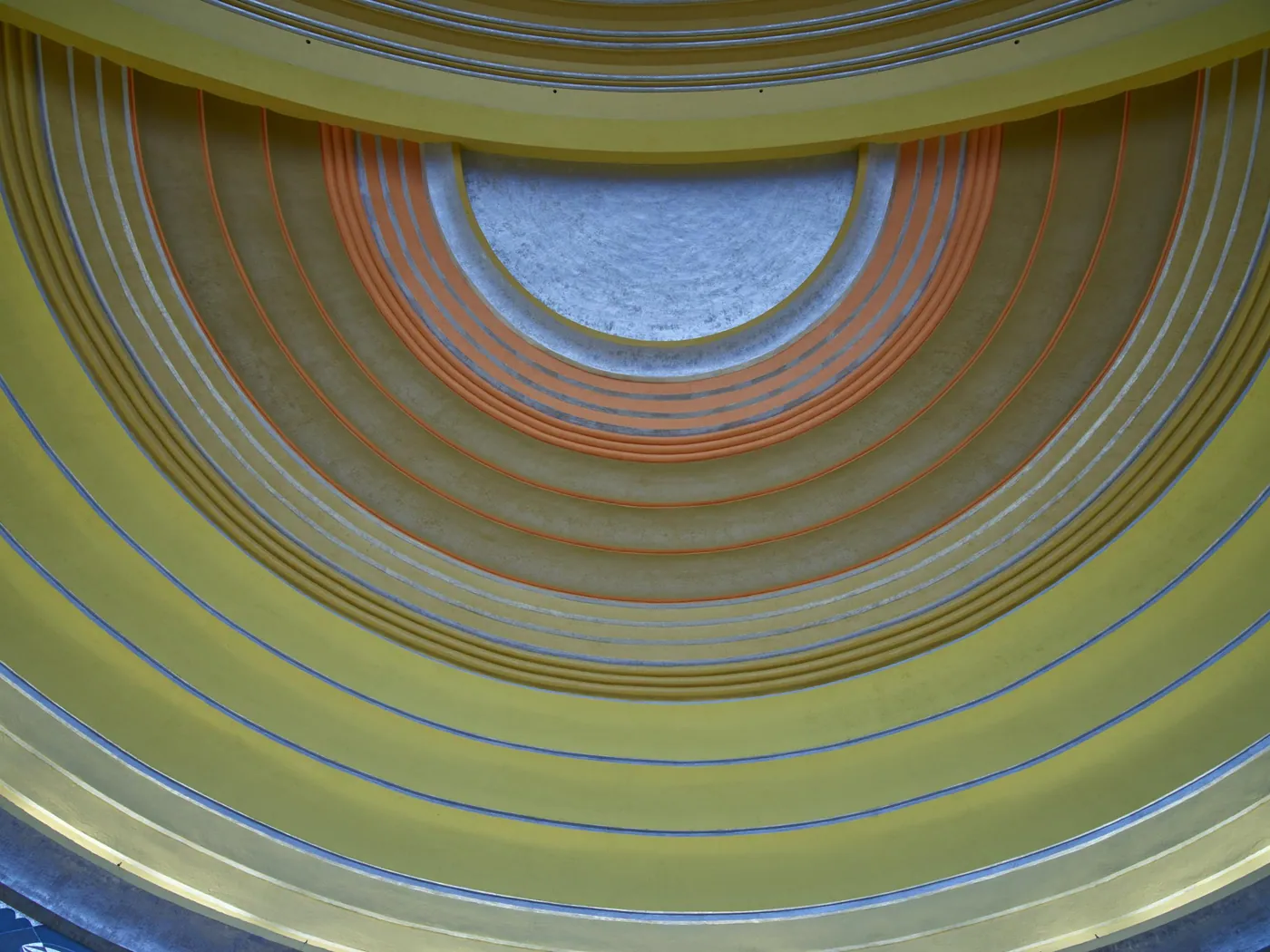 Art Deco ceiling of concentric painted bands in yellow, ochre and orange with thin silver lines, rising in arcs like a sunrise