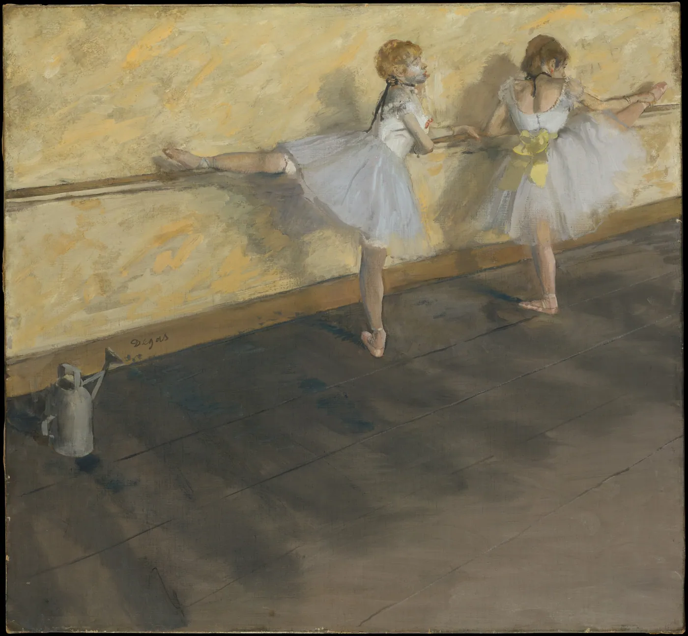 Two ballet dancers in white tutus stretch at a wooden barre, one with her leg raised along the rail, a watering can on the floor