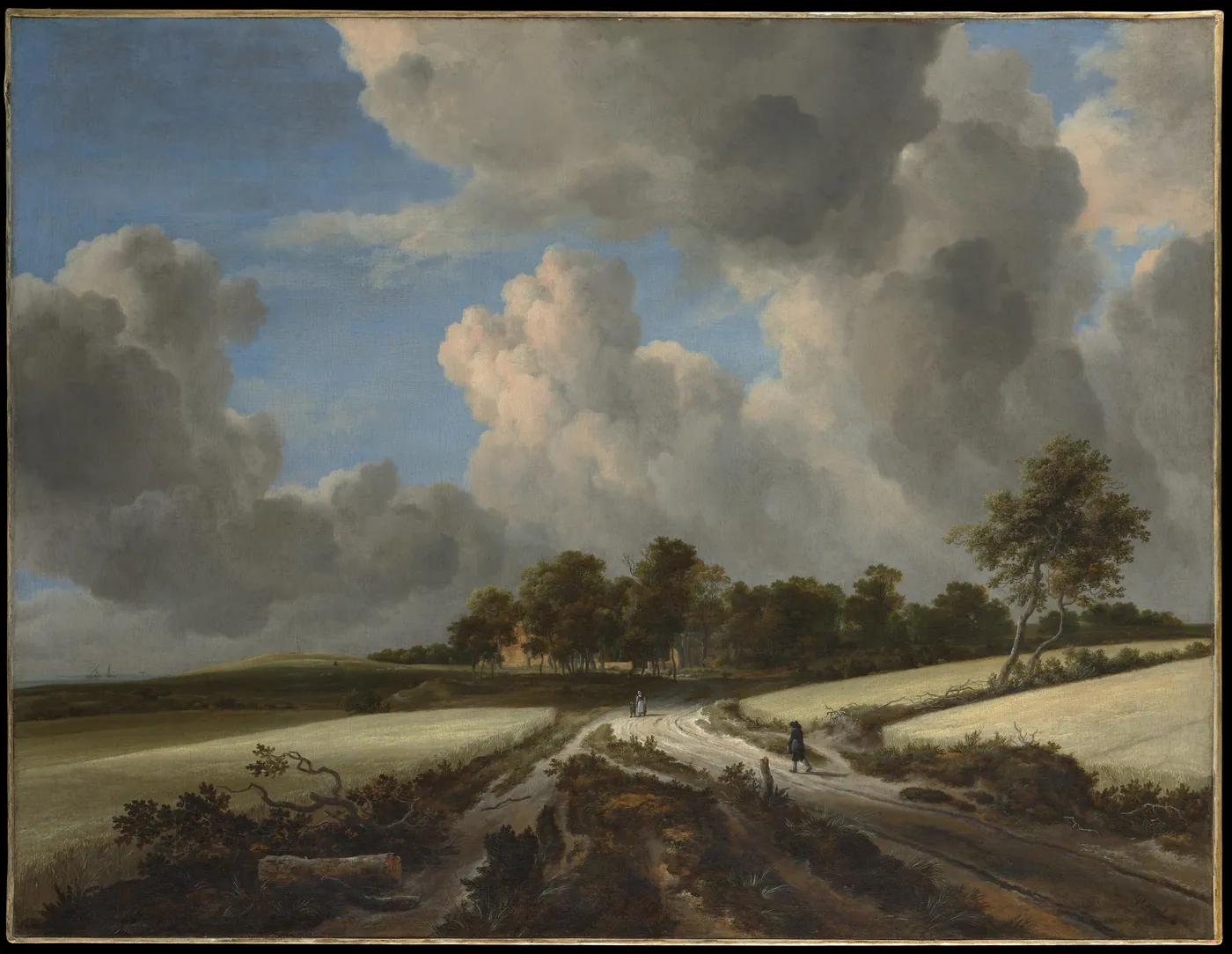 Dutch landscape of a sandy road that forks between pale wheat fields toward a line of trees, two walkers on it, under towering sunlit clouds