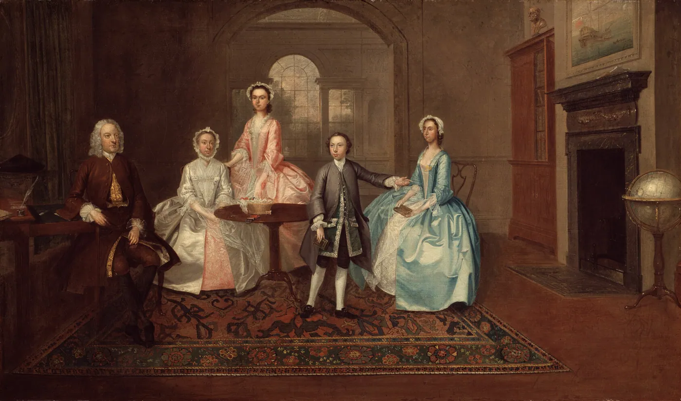 An eighteenth-century family portrait: a seated man, an older woman in white and three grown children in silk dress, gathered in a panelled drawing room with a globe.