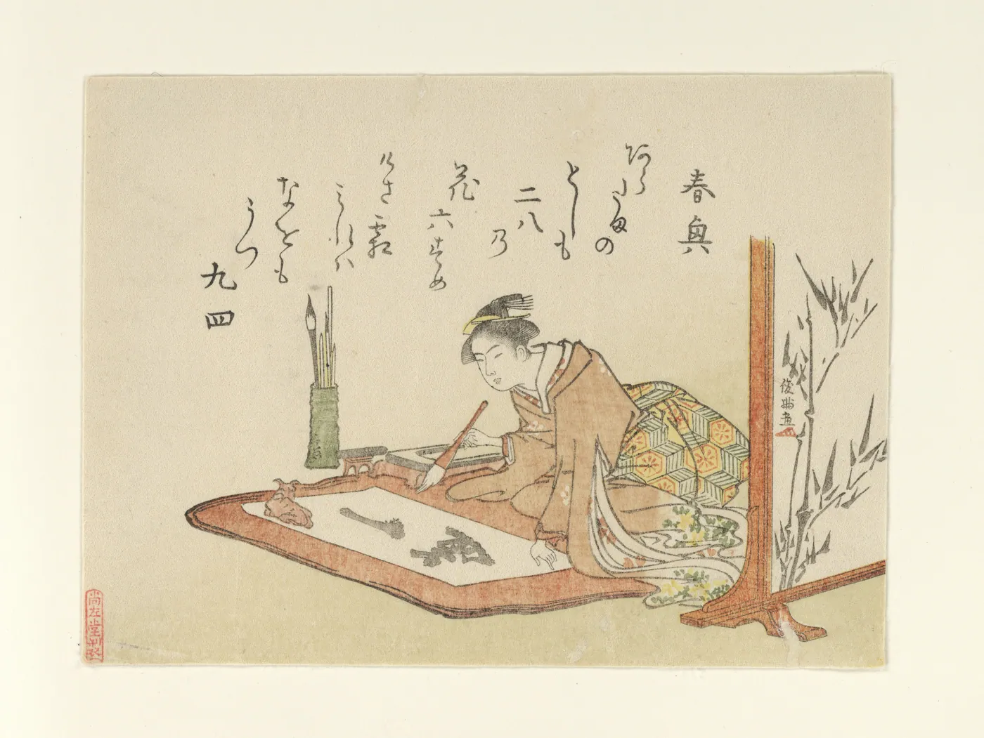 Japanese woodblock print of a kneeling woman in a patterned kimono brushing characters onto paper, with brushes, a screen and bamboo beside her