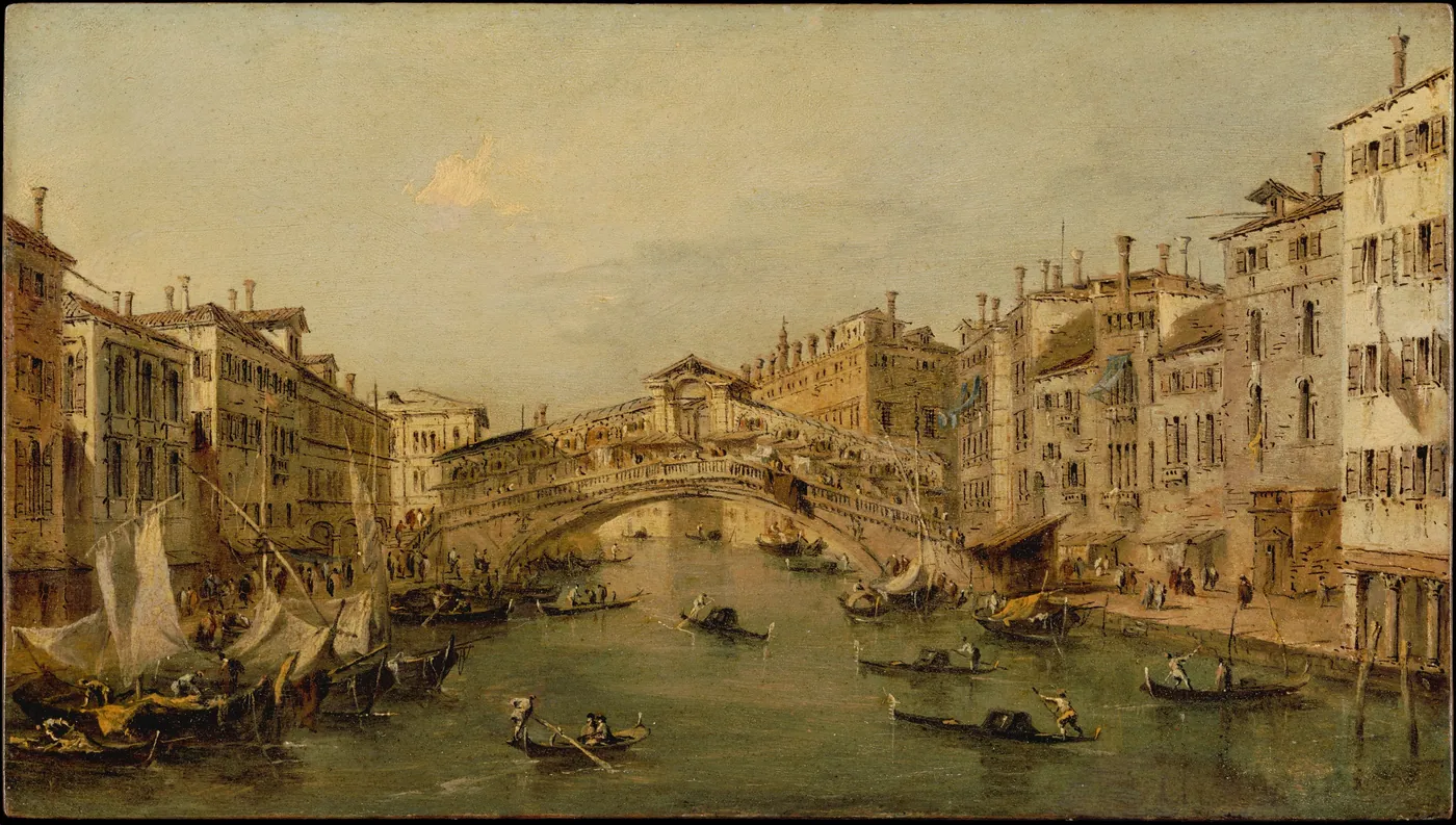 Gondolas and moored sailing boats crowd the Grand Canal before the arched stone Rialto Bridge, lined with tall pale palazzi.
