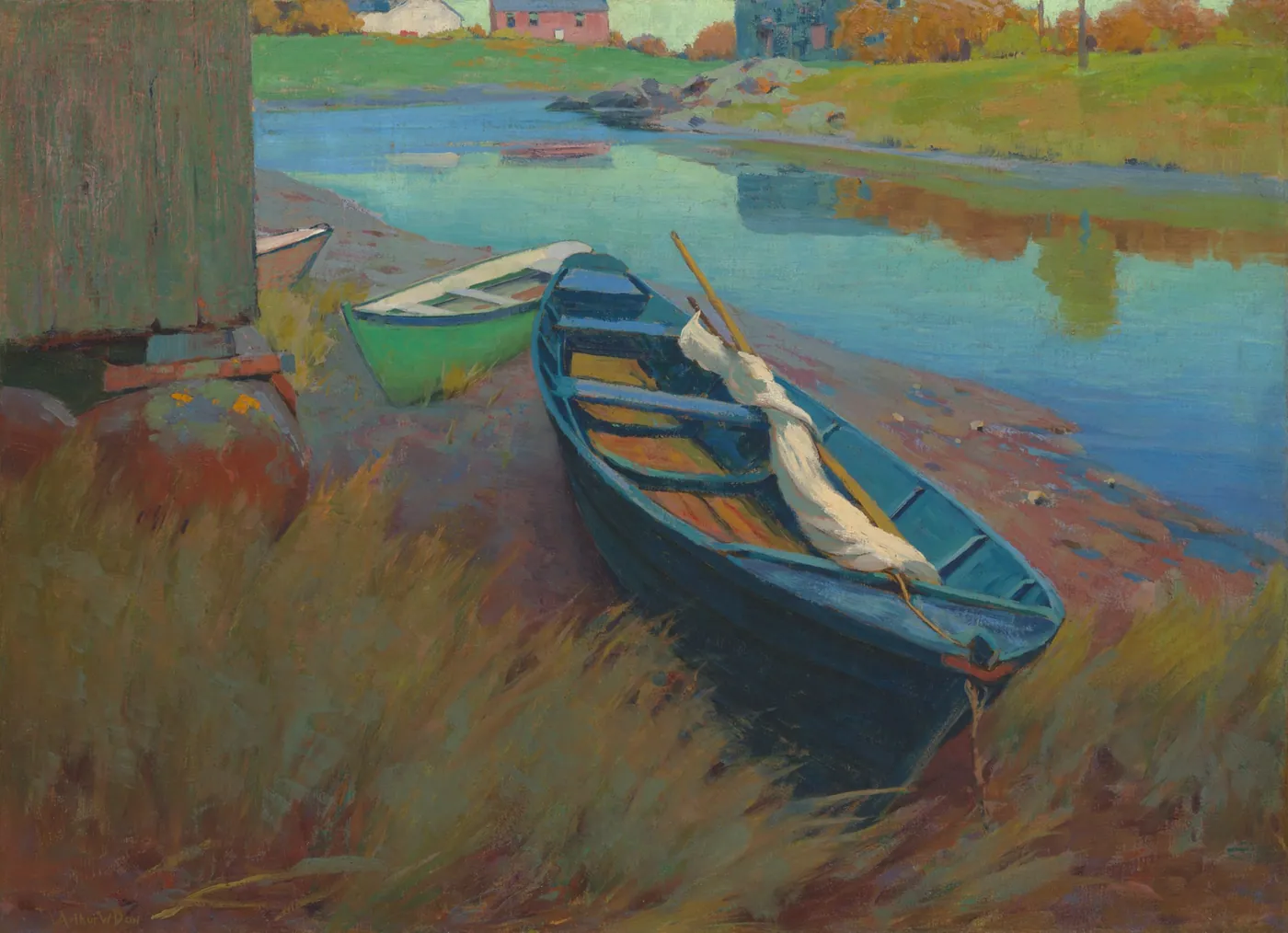 A blue rowboat with a furled white sail and a green skiff drawn up on a grassy shore beside a calm inlet, houses on the far bank