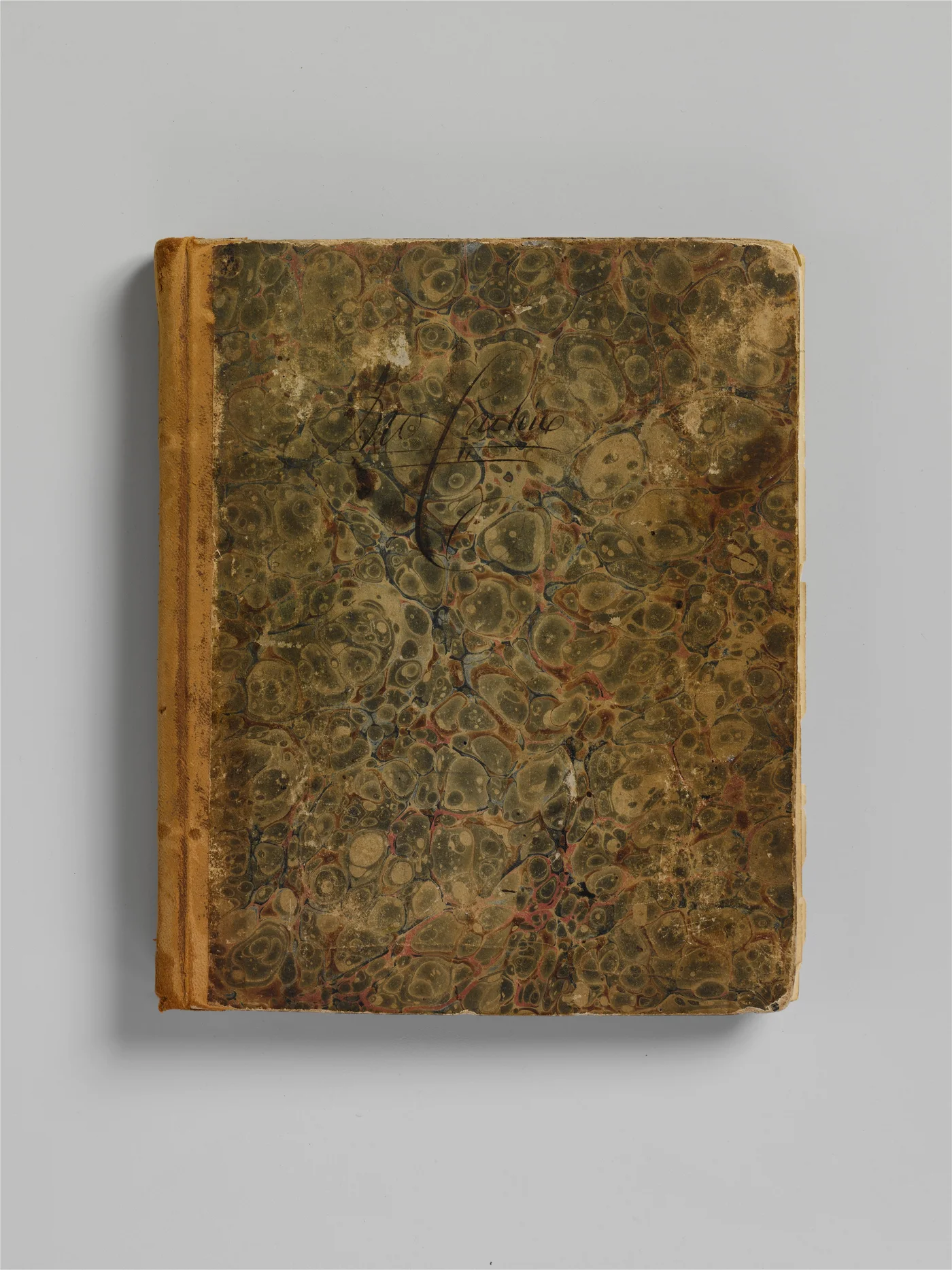A closed nineteenth-century account ledger with a worn marbled cover rests against a pale neutral background