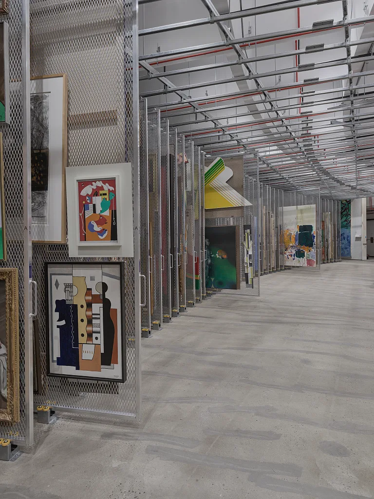 Paintings hang on rolling wire-mesh racks in the Hirshhorn Museum art storage area